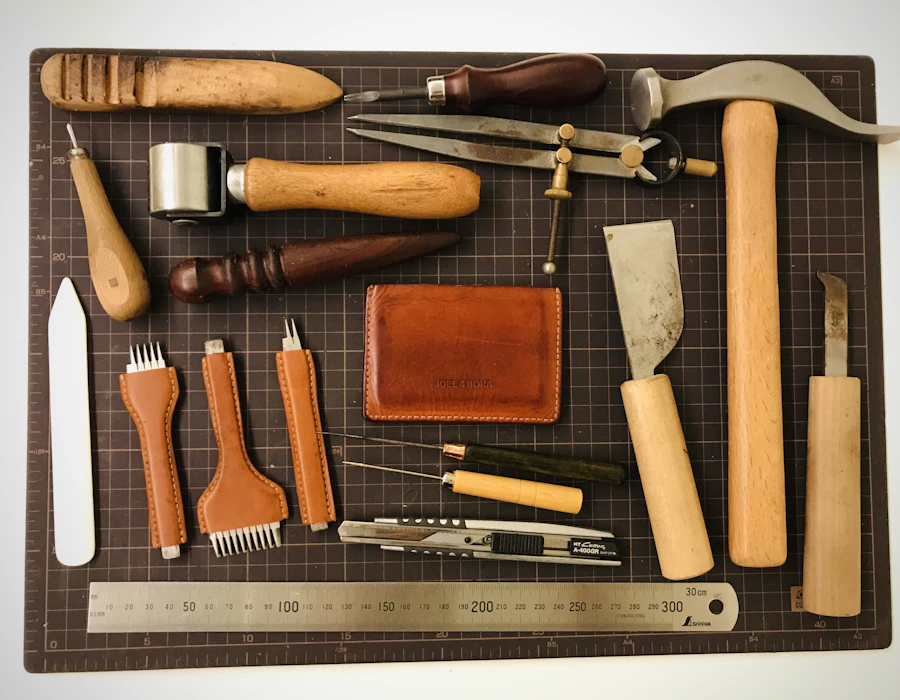 Outils de sellier disposés sur un tapis de coupe : alênes, griffes, maillet et tranchet