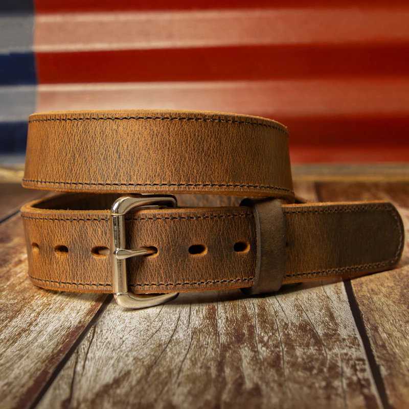 Ceinture en cuir brun clair enroulée, boucle en laiton vieilli