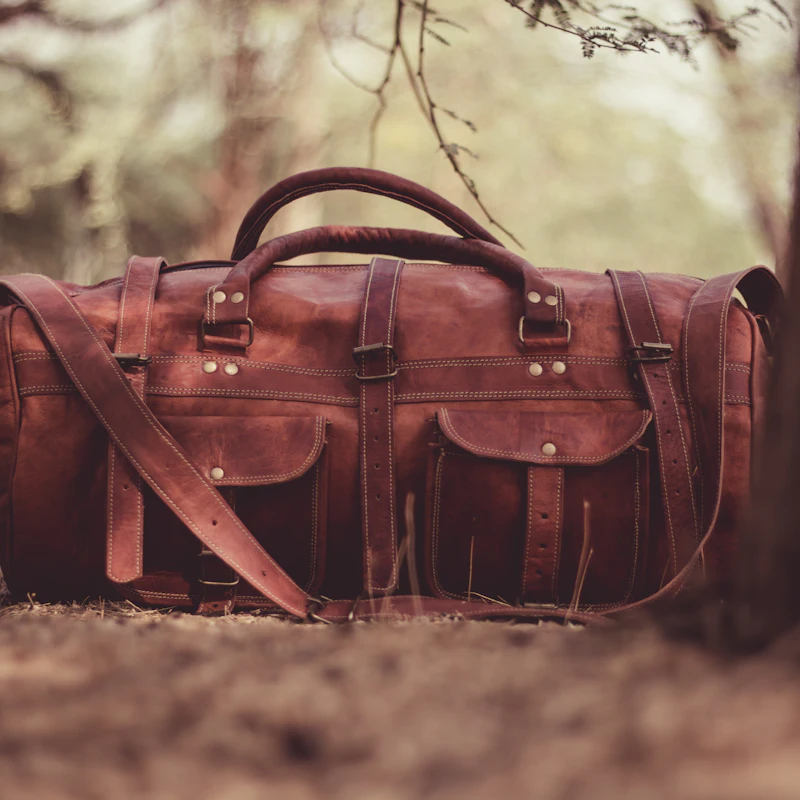 Grand sac de voyage en cuir brun à poches latérales